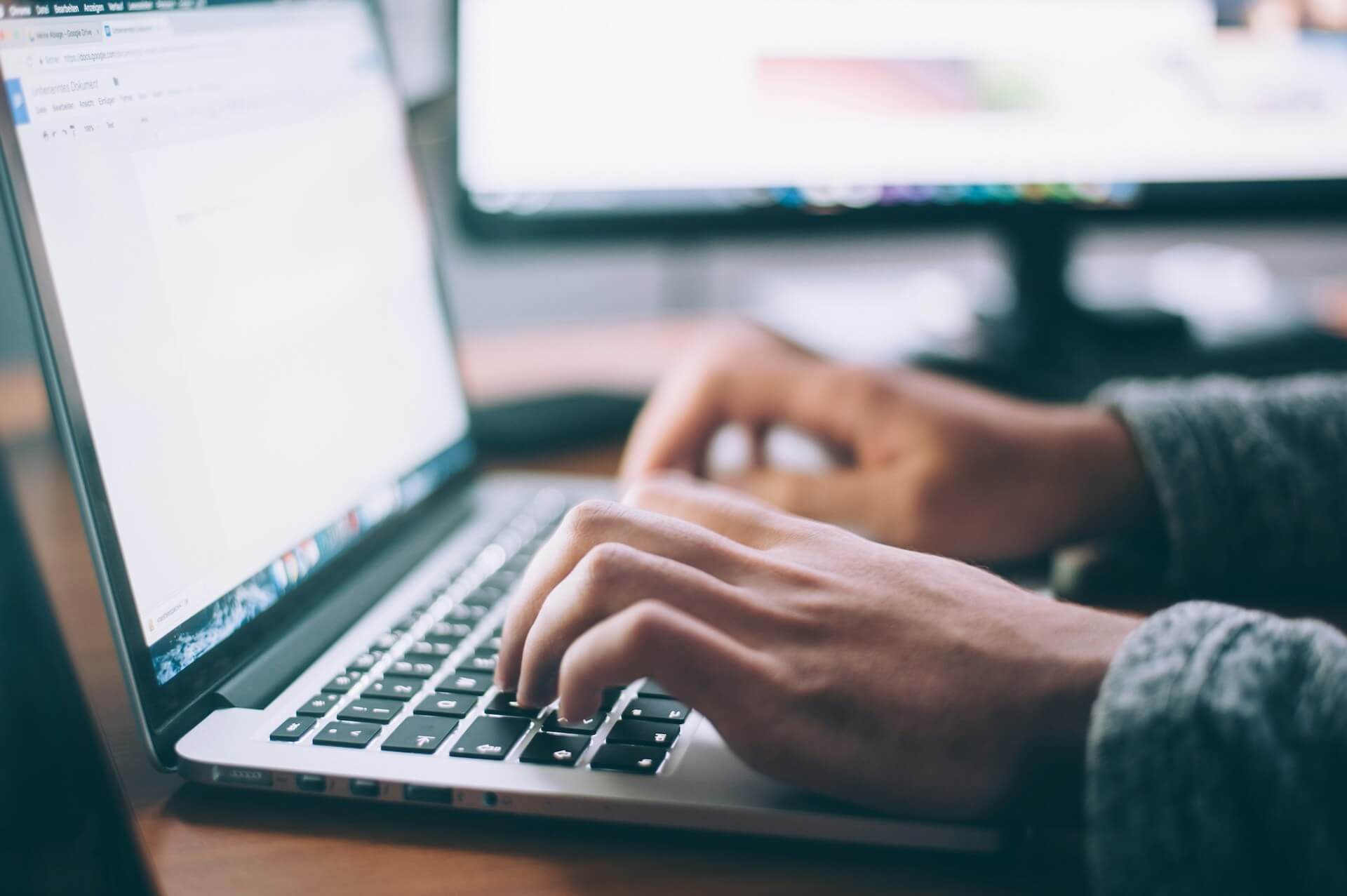 image of a man typing on a laptop